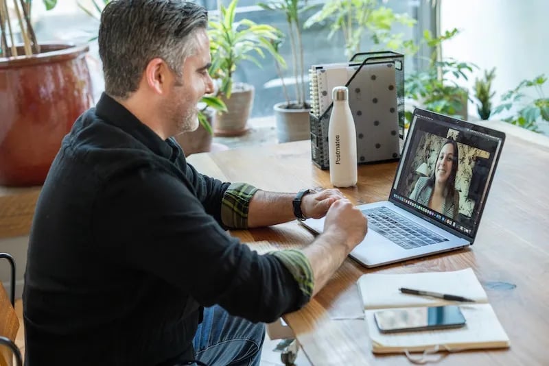 Man on laptop interviewing a candidate over Zoom